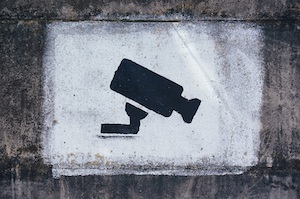 Affordable Orange County Theft Defense Attorney Spray Painted Sign on a Brick Wall Alerting That You are Being Recorded